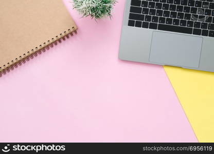 Creative flat lay photo of workspace desk. Top view office desk . Creative flat lay photo of workspace desk. Top view office desk with laptop and blank empty notebooks on pastel pink yellow color background. Top view with copy space, flat lay photography.