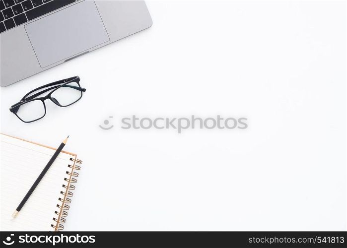 Creative flat lay photo of workspace desk. Top view office desk with laptop, glasses, pencil, notebook and plant on white color background. Top view with copy space, flat lay photography.