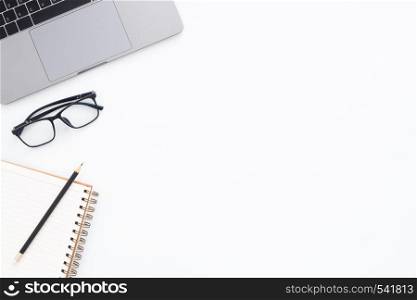 Creative flat lay photo of workspace desk. Top view office desk with laptop, glasses, pencil, notebook and plant on white color background. Top view with copy space, flat lay photography.