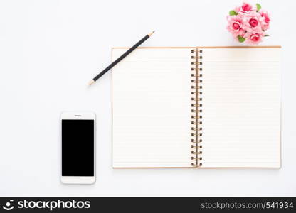 Creative flat lay photo of workspace desk. Top view office desk with phone, pencil, blank notebook and plant on white color background. Top view with copy space, flat lay photography.