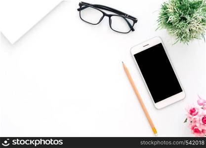 Creative flat lay photo of workspace desk. Top view office desk with phone, pencil, glasses and plant on white color background. Top view with copy space, flat lay photography.