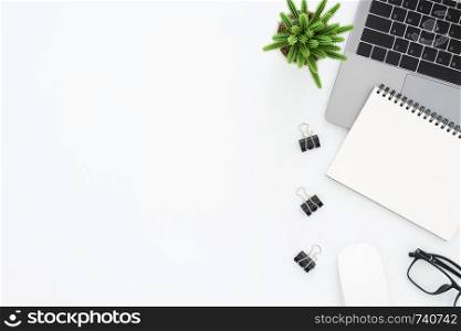 Creative flat lay photo of workspace desk. Top view office desk with laptop, glasses, notebook and plant on white color background. Top view with copy space, flat lay photography.
