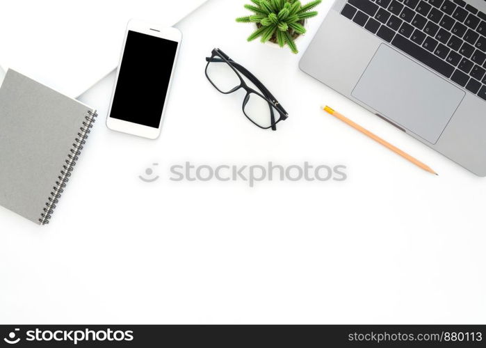 Creative flat lay photo of workspace desk. Top view office desk with laptop, glasses, phone, pencil, notebook and plant on white color background. Top view with copy space, flat lay photography.