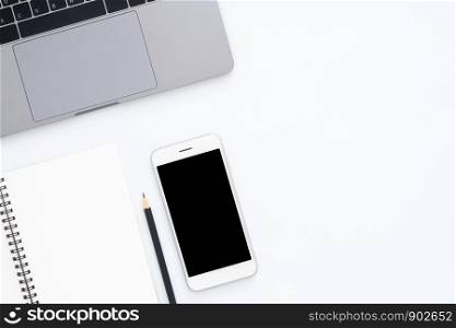 Creative flat lay photo of workspace desk. Top view office desk with laptop, phone, pencil and notebook on white color background. Top view with copy space, flat lay photography.