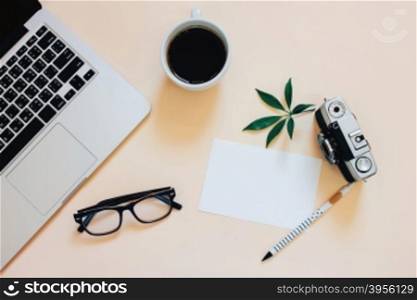 Creative flat lay photo of workspace desk with laptop, coffee, blank paper and film camera with copy space background, minimal styled&#xD;