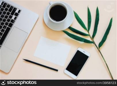 Creative flat lay photo of workspace desk with laptop, smartphone, coffee and blank paper with copy space background, minimal style&#xD;
