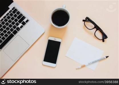 Creative flat lay photo of workspace desk with laptop, smartphone, coffee and blank paper with copy space background, minimal style&#xA;