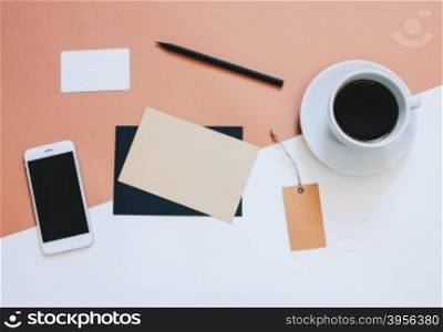 Creative flat lay photo of workspace desk with smartphone, coffee, tag and letter with copy space background, minimal styled&#xD;