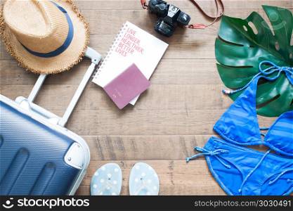 Creative flat lay summer vacation concept with suitcase, passpor. Creative flat lay summer vacation concept with suitcase, passport, camera and bikini on wooden background