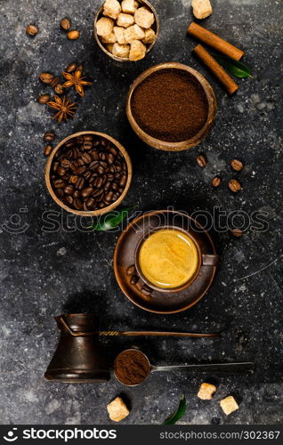 Creative flat lay with milled coffee, coffee beans, brown sugar and espresso on dark rustic background, copyspace. Creative flat lay with milled coffee, coffee beans, brown sugar and espresso