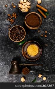 Creative flat lay with milled coffee, coffee beans, brown sugar and espresso on dark rustic background, copyspace. Creative flat lay with milled coffee, coffee beans, brown sugar and espresso