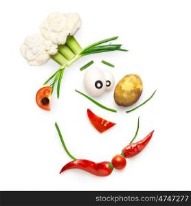 Creative food concept of a funny cartoon chef face made of vegetables isolated on white.