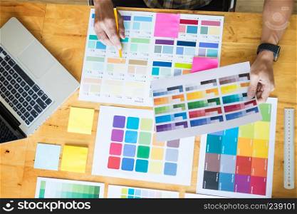 Creative Graphic designer at work. Color swatch samples pantone palette in studio modern office, interior design, renovation and technology concept