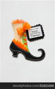 Creative halloween concept photo of witches shoe made of paper on white background.