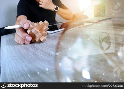 creative hand showing wood puzzle and light bulb with laptop computer and tablet computer as design concept