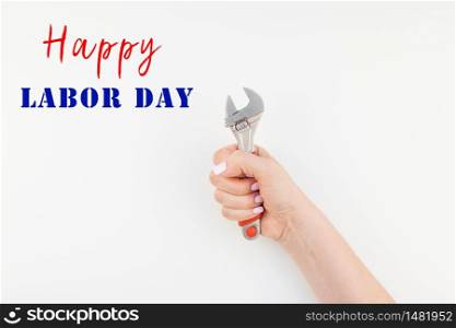 Creative image of woman hand with pastel manicure polish holding spanner with copy space isolated on white background in minimalism style. Repair or improvement feminism concept