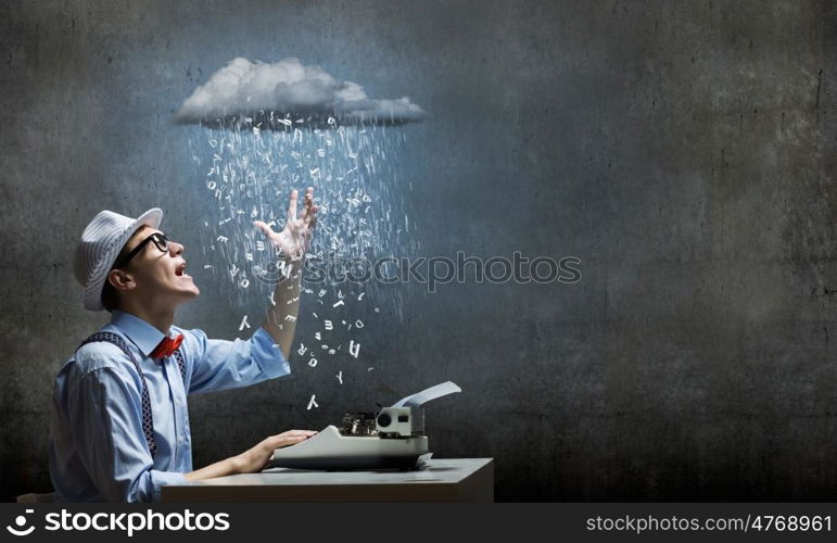 Creative inspiration. Young funny man in glasses writing on typewriter