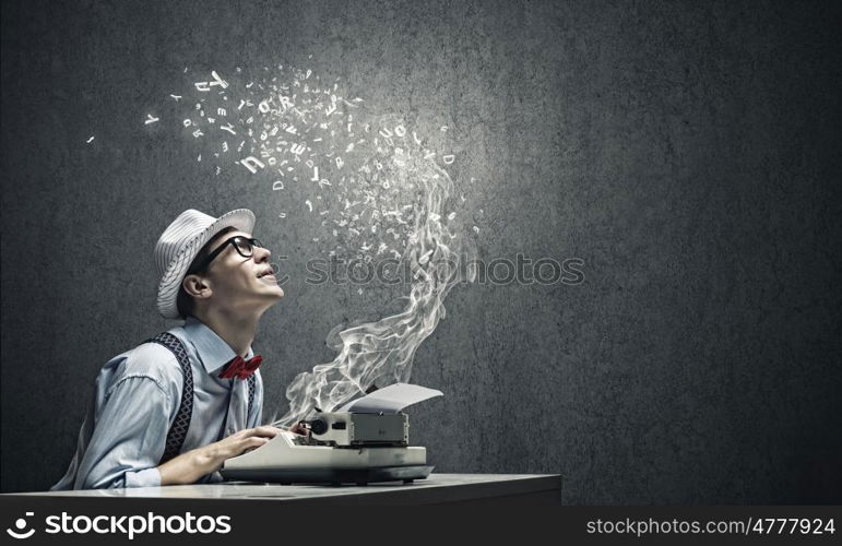 Creative inspiration. Young funny man in glasses writing on typewriter