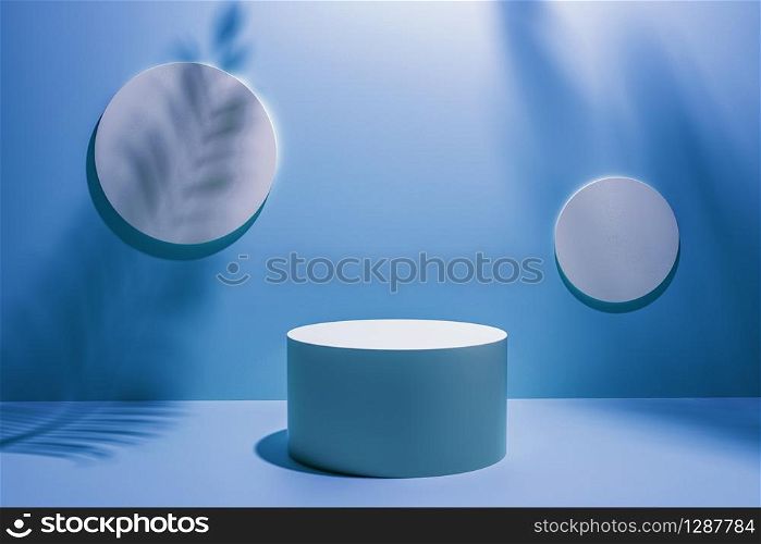 Creative layout made of blue studio background for product placement or display with a circular plinth in front of two blank round wall plaques with the shadows of palm tree fronds.