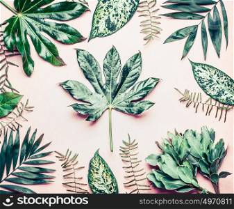 Creative layout made of various tropical palm and fern leaves. Exotic plants on pastel pink background, top view, flat lay
