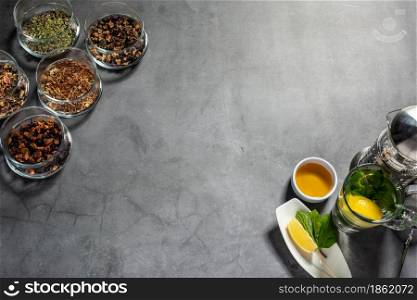 Creative layout made with tea, green tea, black tea and various fruit and herbal teas on dark stone background. Flat laying.