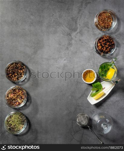 Creative layout made with tea, green tea, black tea and various fruit and herbal teas on dark stone background. Flat laying.