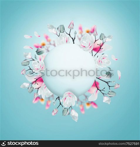 Creative layout with pink and white spring blossom branches made in shape of circle frame at light blue background. Magnolia blooming springtime wreath. Pastel color flowers arrangement. Floral frame