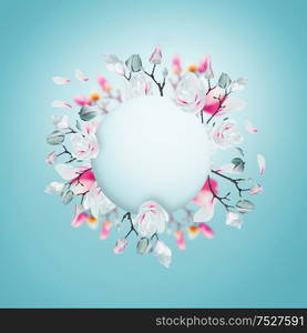 Creative layout with pink and white spring blossom branches made in shape of circle frame at light blue background. Magnolia blooming springtime wreath. Pastel color flowers arrangement. Floral frame