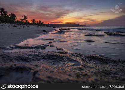 Creative low angle landscape with a rocky beach and colorful sky