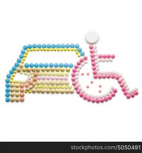 Creative medicine and healthcare concept made of drugs and pills, isolated on white. Abstract wheelchair invalid symbol, disabled person in a wheelchair in front of a car.