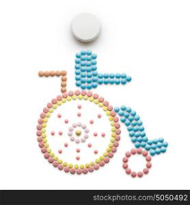 Creative medicine and healthcare concept made of drugs and pills, isolated on white. Abstract wheelchair invalid symbol, disabled person sitting in a wheelchair.