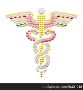 Creative medicine and healthcare concept made of drugs and pills, isolated on white. Caduceus medical symbol and symbol of commerce featuring intertwined snakes around a winged rod.