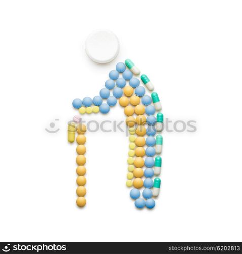 Creative medicine and healthcare concept made of drugs and pills, old man with cane walking isolated on white.