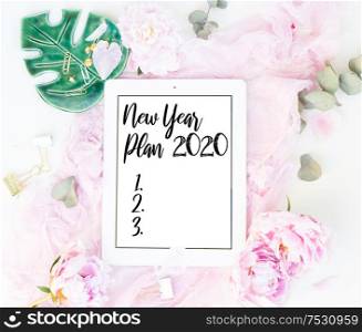 Creative New 2020 year planner composition mock up, pink blanket, flowers on white background, copy space on screen. Flat lay, top view stylish art concept.. Creative wedding composition