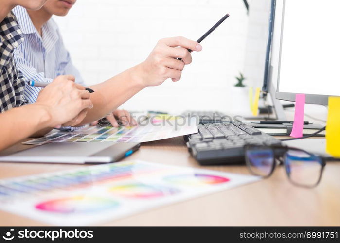 Creative or Interior designers teamwork with pantone swatch and building plans on office desk, architects choosing color samples for design project