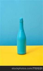 Creative painted spray mock-up blue on a duotone yellow-blue background with copy space. Minimalism concept.. Blue painted holiday mockup bottle on a duotone background.