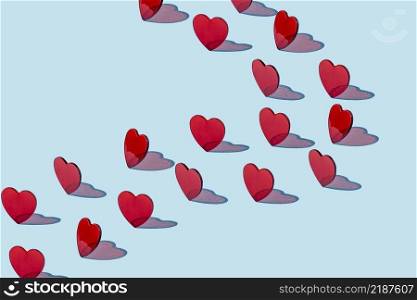 Creative pattern of red hearts on a blue background. Valentine’s day concept. Isometric layout.. Creative pattern of red hearts on a blue background.