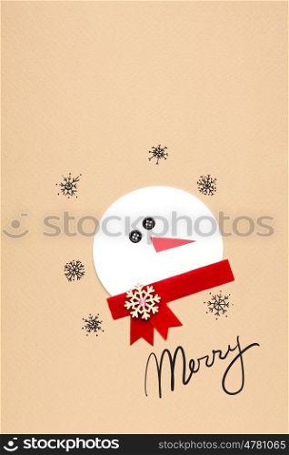 Creative photo of a snowman mad of paper on brown background.