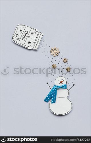 Creative photo of a snowman made of paper on grey background.