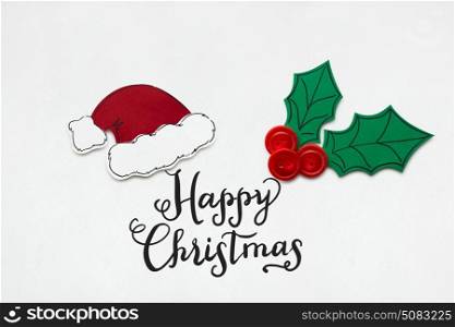 Creative photo of santas hat and holly berry made of paper on white background.