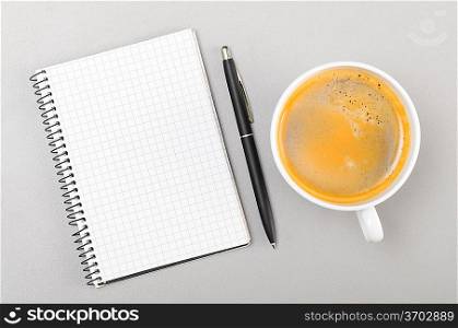 creative process. blank notebook and cup on gray