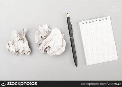 creative process. crumpled wads and blank notebook