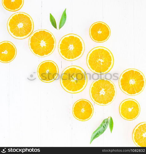 Creative scandinavian style flat lay top view of fresh orange fruit slices on white wooden table background with copy space. Minimal summer fresh citrus pattern for blog or recipe book