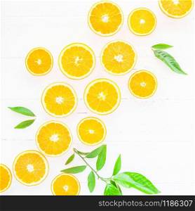 Creative scandinavian style flat lay top view of fresh orange fruit slices on white wooden table background with copy space. Minimal summer fresh citrus pattern for blog or recipe book