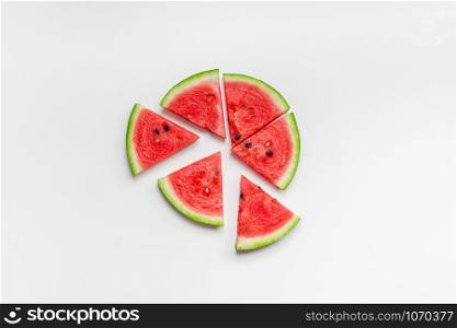 Creative scandinavian style flat lay top view of fresh watermelon slices on white table background copy space. Minimal summer fruits creative for blog or recipe book