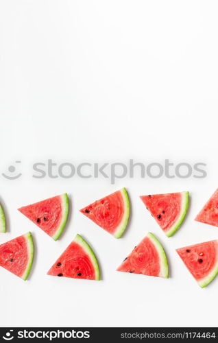 Creative scandinavian style flat lay top view of fresh watermelon slices on white table background copy space. Minimal summer fruits pattern for blog or recipe book