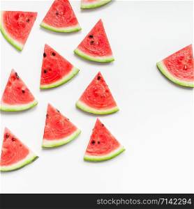 Creative scandinavian style flat lay top view of fresh watermelon slices on white table background copy space. Minimal summer fruits pattern for blog or recipe book