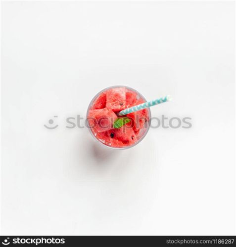 Creative scandinavian style flat lay top view of fresh watermelon slices smoothie drink in glass on white table background copy space. Minimal summer fruits concept for blog or recipe book