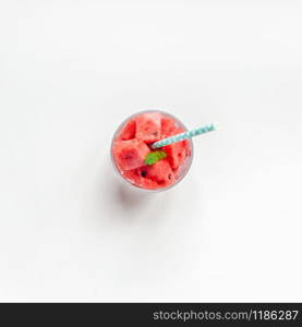 Creative scandinavian style flat lay top view of fresh watermelon slices smoothie drink in glass on white table background copy space. Minimal summer fruits concept for blog or recipe book