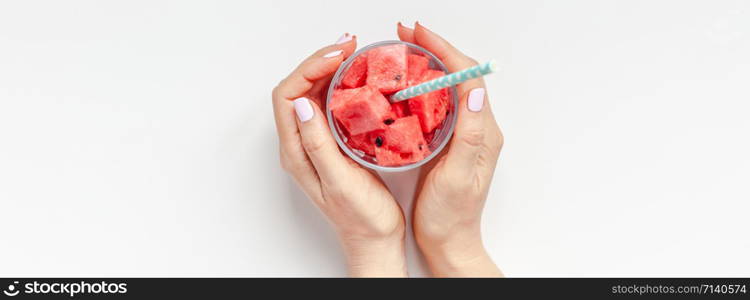 Creative scandinavian style flat lay top view of fresh watermelon slices smoothie drink in glass woman hands on white table background copy space. Minimal summer fruits concept for blog or recipe book